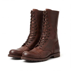 May include: A pair of brown leather combat boots with a lace-up design. The boots have a cap toe and a sturdy sole. The leather has a distressed appearance, giving them a vintage look. The boots are suitable for various outdoor activities.
