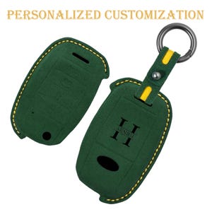 May include: Green key fob cover with yellow stitching and a metal keyring. The cover has the text "TERNITY" and the words "PERSONALIZED CUSTOMIZATION" in gold letters. The cover is made of a soft material.