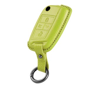 Könnte beinhalten: Eine limettengrüne Leder-Autoschlüsselhülle mit passendem Riemen und einem silberfarbenen Schlüsselring. Die Hülle hat geprägte Symbole für Verriegeln, Entriegeln und andere Funktionen. Die Nähte sind an den Rändern sichtbar.