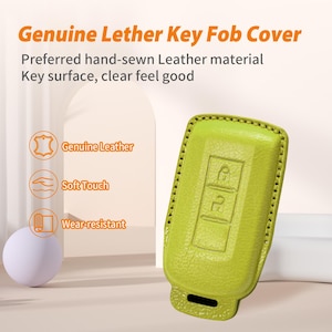 May include: A lime green leather key fob cover with the text "Genuine Lether Key Fob Cover". The cover has a stitched border and embossed key symbols. The image also includes text that says "Genuine Leather", "Soft Touch", and "Wear-resistant".