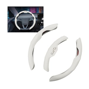 May include: White steering wheel cover set with the text "BLITZ" and "Elizabeth Taylor". The set includes a steering wheel cover and three additional pieces. The covers are white with a textured pattern and red accents.