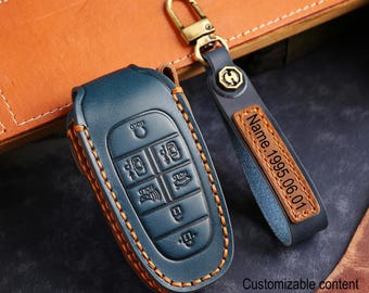May include: A blue leather car key fob cover with orange stitching and a matching keychain. The fob cover has embossed buttons and the keychain has a leather tag with the text "Name.1995.06.01". The words "Customizable content" are also visible.