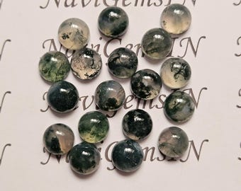 May include: A collection of round, polished moss agate gemstones. The stones vary in color, with shades of green, white, and gray. The gemstones are arranged on a white surface with the text "NaviGemsIN" in a script font.
