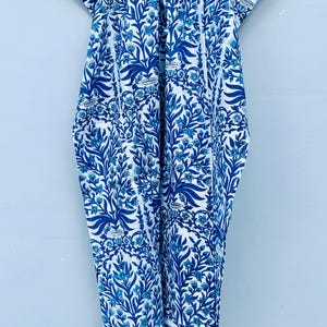 May include: A blue and white patterned garment with a floral design. The fabric features a repeating pattern of stylized leaves and flowers in varying shades of blue against a white background. The garment appears to be a loose-fitting dress or cover-up.