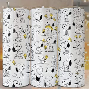 May include: Three white stainless steel tumblers with a repeating pattern of Snoopy and Woodstock cartoon characters in black and yellow. The design includes hearts and clouds. Each tumbler has a silver straw.