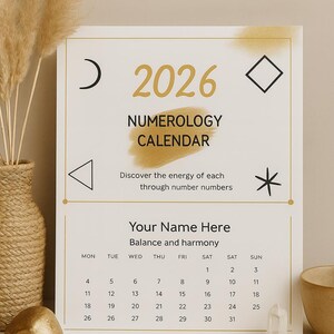 May include: A 2026 numerology calendar with gold text and geometric shapes. The calendar includes space for a name and a monthly layout. Decorative elements include pampas grass and a crystal.