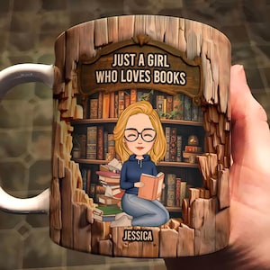 May include: A white ceramic mug with a cartoon illustration of a woman reading in a library. The mug has the text "JUST A GIRL WHO LOVES BOOKS" and the name "JESSICA". The design includes a bookshelf and a wooden frame.
