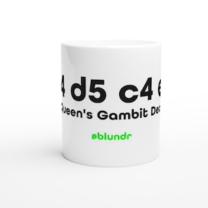 Könnte beinhalten: Weißer Keramikbecher mit schwarzem Text "4 d5 c4" und "Queen's Gambit De". Der Becher hat auch das Wort "blundr" in Grün. Der Becher ist zylindrisch und hat einen Henkel.