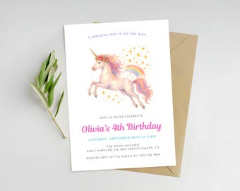 May include: A white invitation card with a watercolor illustration of a unicorn with a rainbow mane and tail. The text reads "Olivia's 4th Birthday" and includes event details. A brown envelope is behind the card.