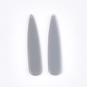 May include: Two grey teardrop-shaped earrings with a hole at the top for hanging.