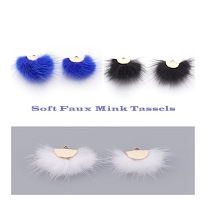 Peut inclure: Trois paires de boucles d'oreilles en fausse fourrure bleue, noire et blanche. Chaque paire présente une forme de croissant en métal doré avec un pompon en fourrure moelleux.