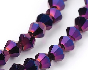 Puede incluir: Una hebra de cuentas de cristal facetadas de color púrpura iridiscente. Las cuentas son pequeñas y tienen un acabado brillante.