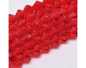 Puede incluir: Una hebra de cuentas de cristal rojo, cada cuenta está facetada y tiene una punta puntiaguda.