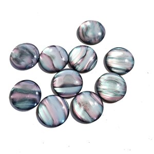 Könnte beinhalten: Zehn runde, irisierende Cabochons mit einem wirbelnden Muster in Rosa, Grau und Schwarz. Die Cabochons sind glatt und glänzend.
