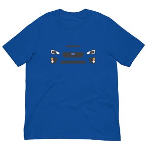 Op de afbeelding: Koningsblauw T-shirt met een afbeelding van de voorkant van een auto. Het ontwerp omvat koplampen, een grille en het embleem van de auto. Het shirt is gemaakt van een zacht materiaal en is geschikt voor vrijetijdskleding.
