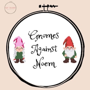 Op de afbeelding: Kruissteekborduurwerk in een ronde hoepel met twee gepixelde kabouters en de tekst "Gnomes Against Noem". Eén kabouter draagt een roze hoed en de andere een rode hoed. De achtergrond is licht perzik van kleur.