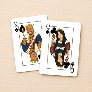 May include: Two custom playing cards featuring illustrated portraits of a king and a queen. The king card displays a spade symbol and a man in royal attire, while the queen card shows a club symbol and a woman holding a flower.