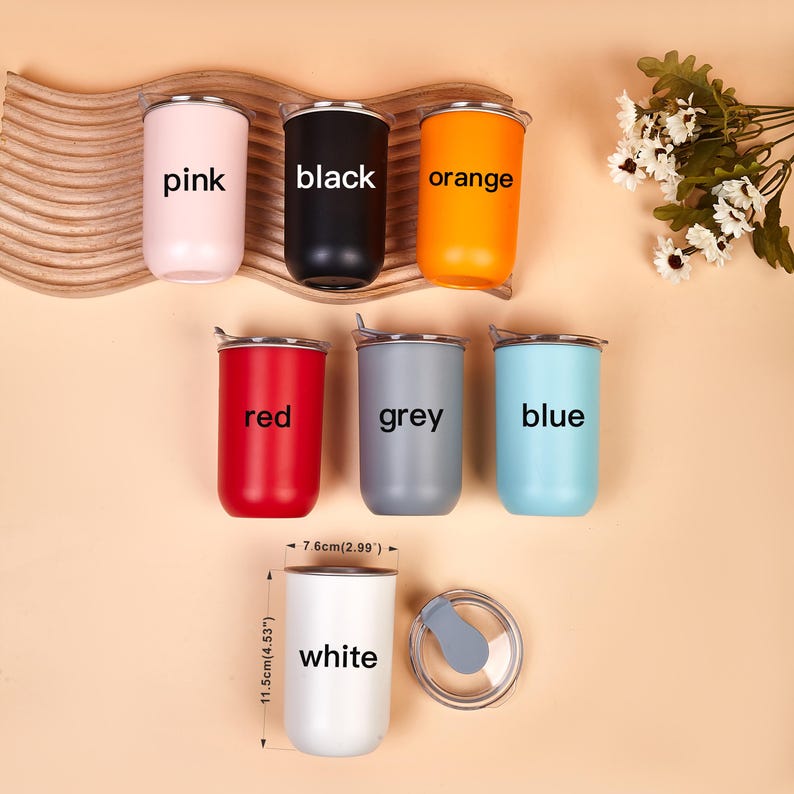 May include: Seven cylindrical tumblers in pink, black, orange, red, grey, blue, and white, each labeled with its color. The white tumbler is shown with a clear lid and dimensions of 11.5cm (4.53 inches) in height and 7.6cm (2.99 inches) in width.
