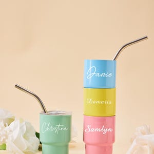 May include: A set of three ceramic mugs with a speckled, matte finish. The mugs are in shades of cream, light gray, and dark gray. Each mug has a simple, minimalist design and a rounded handle.