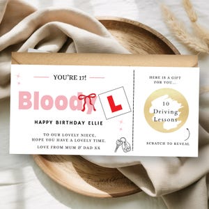 May include: A rectangular birthday gift voucher with white background and black text reading YOU'RE 17! HAPPY BIRTHDAY ELLIE. It features a pink Bloody L graphic, a red bow, a car key icon, and a gold scratch-off circle labeled 10 Driving Lessons.