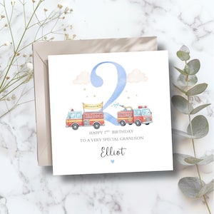 May include: A square birthday card with a watercolor illustration of two red fire trucks and a large blue number 2. The card reads "Happy 2nd Birthday To A Very Special Grandson" and includes the name "Elliot".