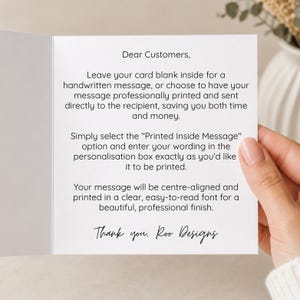 a hand holding a card with a handwritten message on it. The card appears to be a personalized message, and the person holding it is likely the card's recipient.