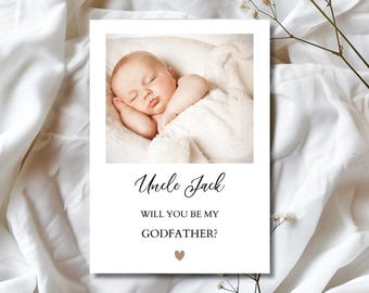 May include: A white card with a photo of a sleeping baby, text that reads "Uncle Jack, will you be my Godfather?" and a small brown heart. The card is on a white background.