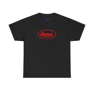 May include: Black t-shirt with a red oval design that says "Gooner" in a cursive font. The shirt is a basic crew neck style, and the text is centered on the chest.