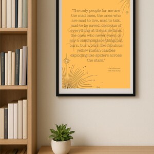 May include: A framed print with a yellow background and black text quoting Jack Kerouac from "On the Road." The quote is surrounded by starburst designs. The frame is black.