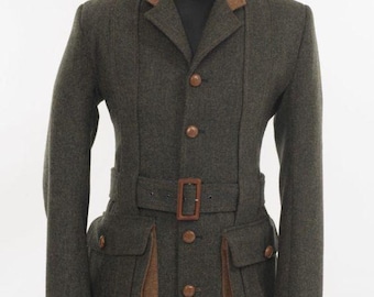 Puede incluir: Chaqueta de lana verde oscuro con cuello y detalles marrones. La chaqueta tiene cinturón en la cintura, dos bolsillos delanteros y botones de madera. La chaqueta se exhibe en un maniquí negro.