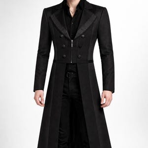 May include: A long, black coat with a double-breasted front, featuring a zipper closure and decorative buttons. The coat has a tailored fit and a long, flowing design, suitable for formal occasions.