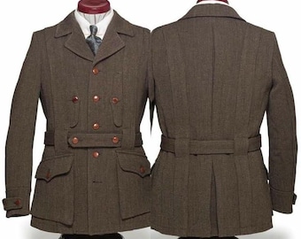 Puede incluir: Chaqueta de lana marrón con doble botonadura, con cuatro botones y dos bolsillos con solapa. La chaqueta tiene cinturón en la cintura y se exhibe en un maniquí. También se ve la parte trasera de la chaqueta.