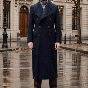 Può includere: Un cappotto doppiopetto blu navy con sei bottoni, indossato con pantaloni marroni e scarpe in pelle marrone scuro. Il cappotto è lungo, arriva alle caviglie. Una sciarpa fantasia è visibile al collo.