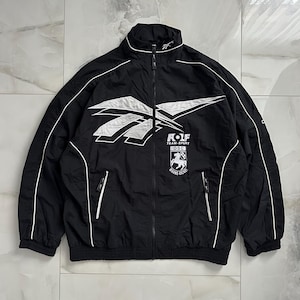 May include: Black zip-up jacket with white accents and a white logo. The jacket features a high collar, two front pockets, and the text "ROLF TEAM-SPORT DSC". The jacket has a sporty aesthetic.