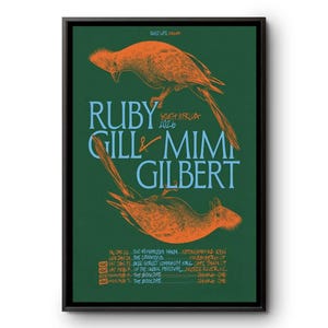 May include: A framed poster with a dark green background features orange bird illustrations and light blue text. The text reads "RUBY GILL & MIM GILBERT SOUTH AFRICA 2026" and lists tour dates and locations.