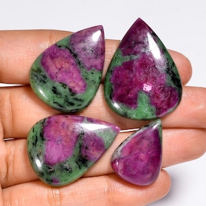 Peut inclure: Quatre pierres précieuses en rubis zoïsite polies en forme de goutte, présentant un mélange vibrant d'inclusions de rubis rose magenta profond sur une matrice de zoïsite verte et noire tachetée, avec une surface lisse et réfléchissante.