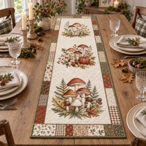 May include: A rectangular quilted table runner featuring a cream-colored center panel with three distinct botanical illustrations of mushrooms, ferns, and autumn leaves, bordered by a patchwork design of brown, green, and floral fabric squares.