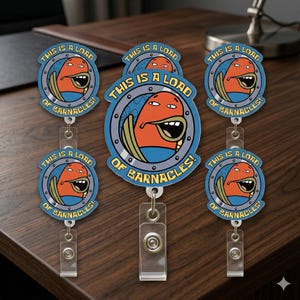 May include: A collection of badge reels featuring a cartoon character with an orange face, blue shirt, and a wide open mouth. The text "THIS IS A LOAD OF BARNACLES!" is printed around the character in a blue circle.