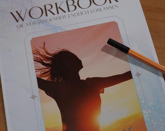 May include: A workbook titled "WORKBOOK" with the text "DIE VERGANGENHEIT ENDLICH LOSLASSEN". The cover features a silhouette of a person with outstretched arms against a sunset backdrop. A pen rests on the page. The text "Lesson of Luck" is at the bottom.