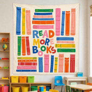 May include: A rectangular wall tapestry featuring a cream background with a colorful illustration of stacked books and the text "READ MORE BOOKS" in large, multi-colored letters. The design includes various book spines in shades of blue, yellow, pink, orange, green, and red.