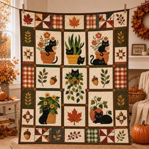May include: A quilted wall hanging featuring a grid of squares with black cat illustrations, potted plants, autumn leaves, acorns, and plaid patterns in shades of orange, green, brown, and cream. The quilt is suspended from a wooden rod.