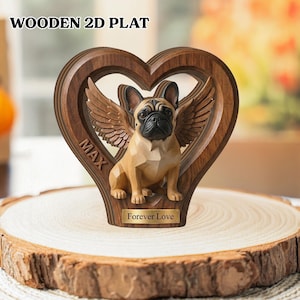May include: Wooden heart-shaped plaque with a carved French bulldog figure with angel wings. The plaque has the word "MAX" carved on the side and "Forever Love" on a small gold plate. The text "WOODEN 2D PLAT" is at the top.