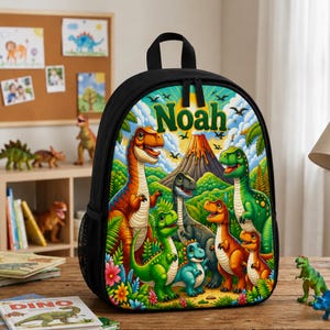 Puede incluir: Una mochila negra que presenta un estampado gráfico vibrante y colorido de varios dinosaurios en un entorno de selva prehistórica con un volcán y el nombre Noah impreso en letras verdes grandes en la parte superior central.