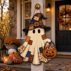 May include: A hanging wooden sign shaped like a ghost wearing a patchwork witch hat. The ghost features various fabric-style patterns in orange, blue, and brown, and holds an orange jack-o'-lantern bucket filled with assorted Halloween candy.