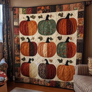Peut inclure: Une tenture matelassée présentant une grille de neuf citrouilles dans divers tissus aux tons automnaux, notamment orange, vert, marron et crème. Chaque citrouille a une tige noire et des feuilles vertes sur un fond crème avec une bordure.
