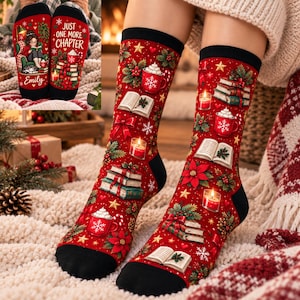 May include: Red crew socks featuring a festive holiday pattern of stacked books, mugs of hot cocoa with whipped cream, lit candles, poinsettias, and small stars. The socks have black cuffs, heels, and toes. The inset shows the text Just One More Chapter.