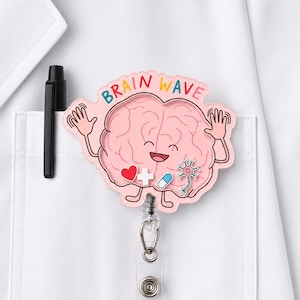 May include: A pink badge reel featuring a cartoon brain with a smiling face, waving arms, and the text BRAIN WAVE. The design includes a red heart, a white cross, a blue pill, and a neuron icon. A black pen is clipped to the white fabric pocket.