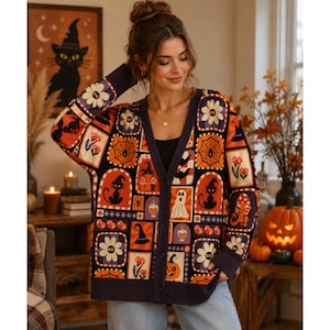 May include: A long-sleeve button-down cardigan featuring a dark background with a repeating grid pattern of Halloween-themed illustrations including black cats, ghosts, pumpkins, spiderwebs, flowers, and witch hats in orange, white, and purple.