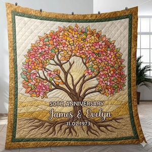 May include: A quilted throw blanket featuring a tree design with colorful leaves. The blanket has a gold border and the text "50th Anniversary" with the names "James & Evelyn" and the date "11.02.1973".