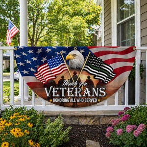 May include: A patriotic banner with the American flag design, an eagle, and the words "Thank you Veterans." The banner also features silhouettes of soldiers and a flag with a green stripe. It is displayed on a white railing.